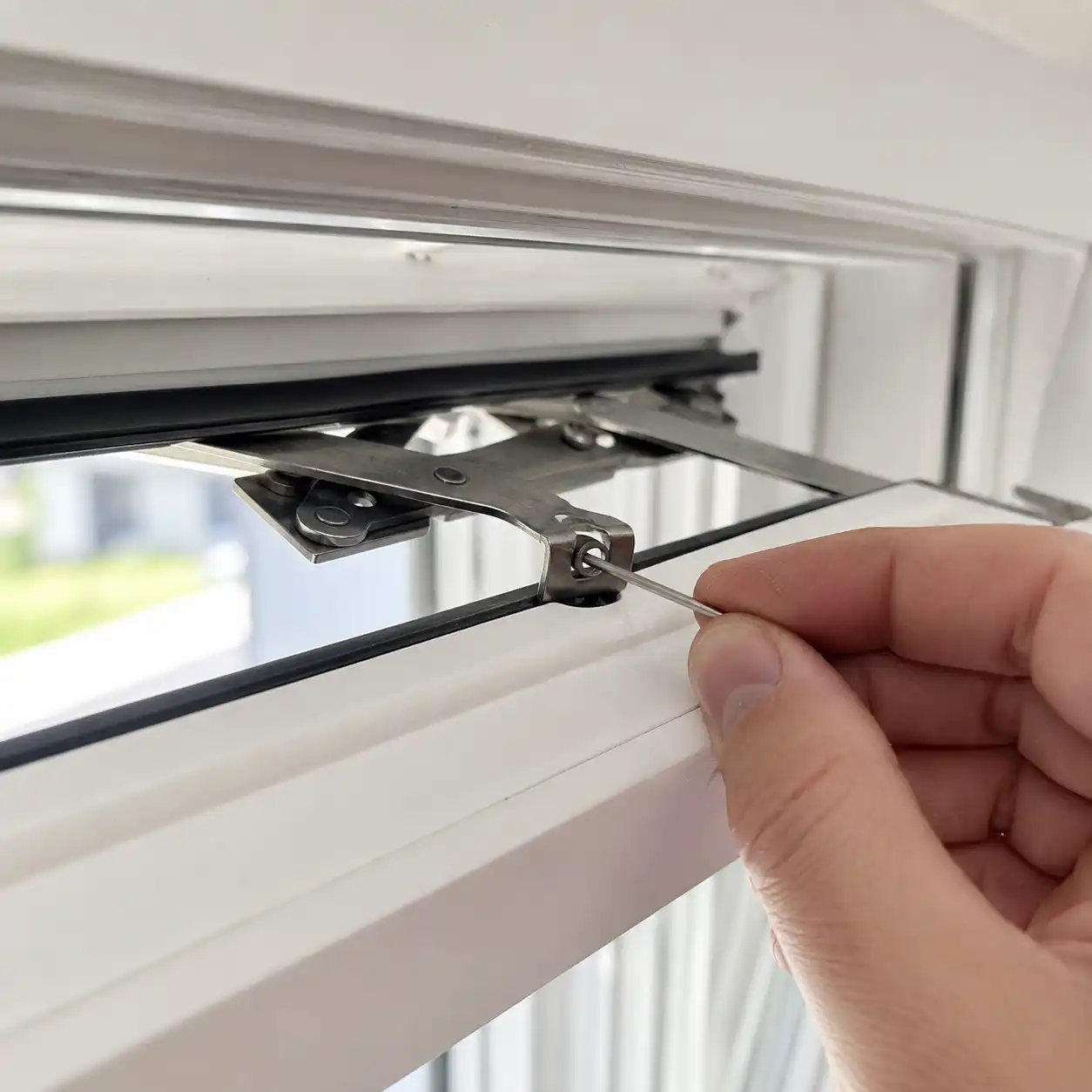 Detail-Ansicht Scherenlager am oberen Flügelrand, Sicherungsstift wird eingesetzt, ecowindow Anleitung Schritt 3