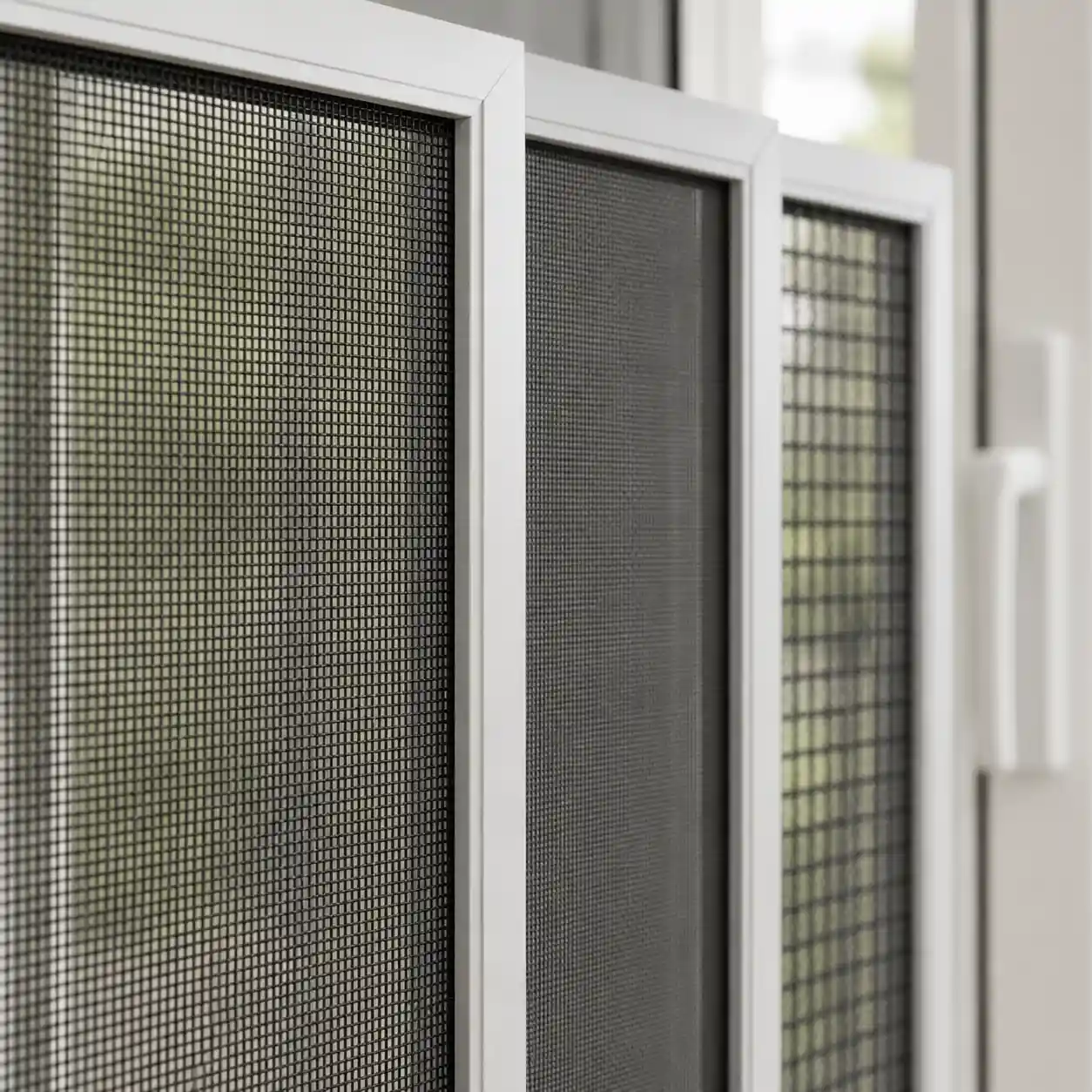 Nahaufnahme verschiedener Fliegengittergewebe im Aluminium-Rahmen einer Balkontür, ecowindow