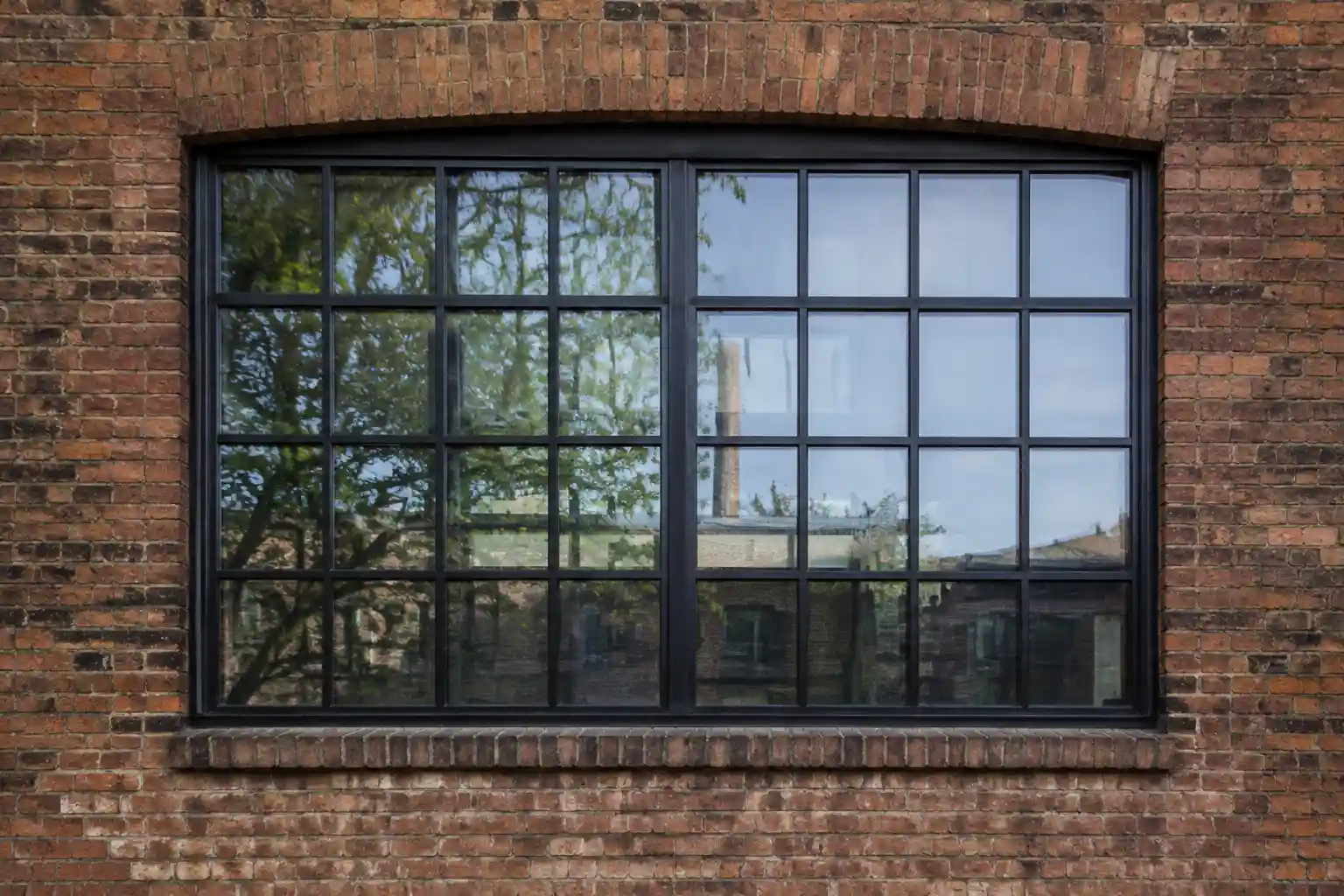 Industriefenster mit grossflaechiger Sprossenteilung an einer Fassade von ecowindow