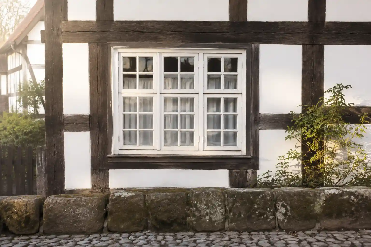 Holzfenster mit engen Sprossenfeldern in einem Fachwerkhaus als Landhausfenster von ecowindow