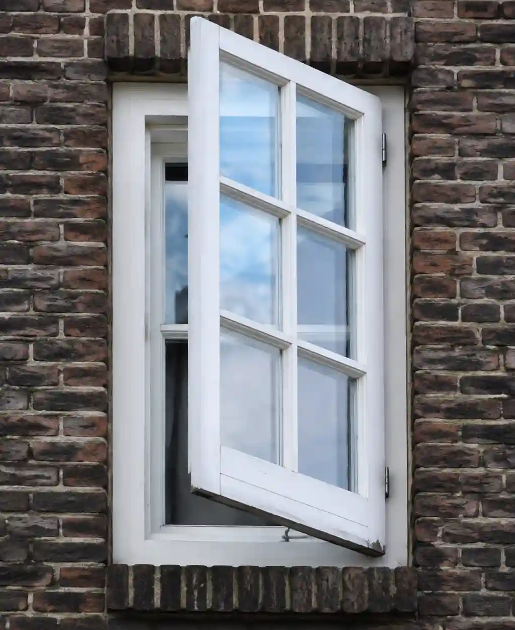 Nach außen geöffneter Fensterflügel an einer norddeutschen Klinkerfassade