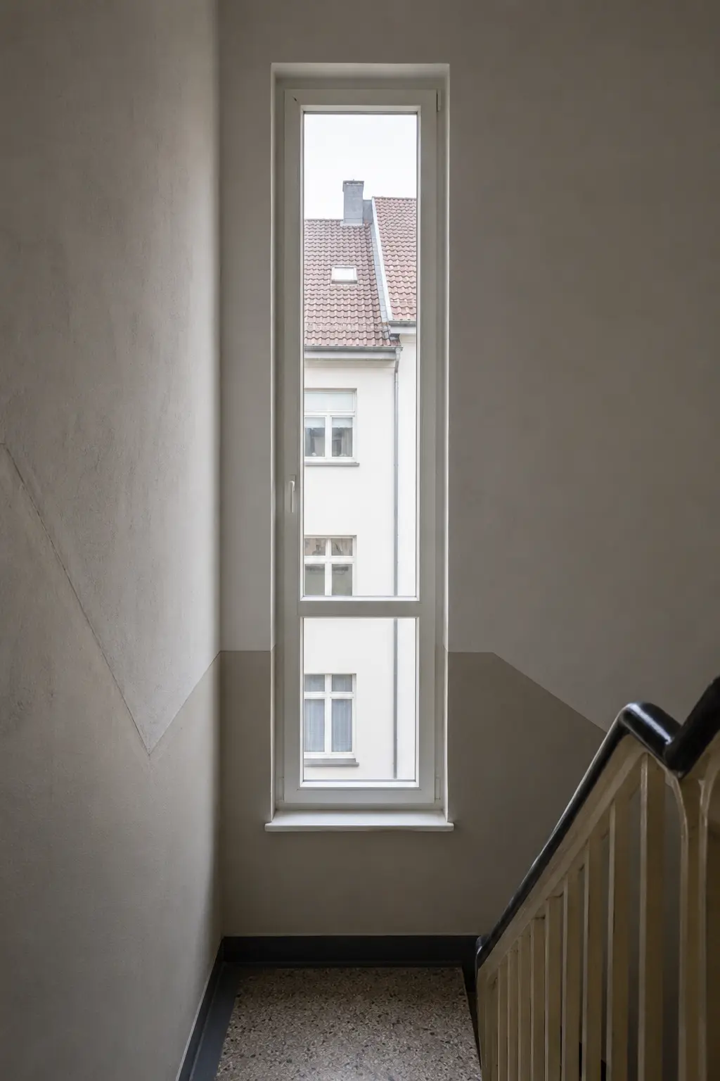 Schmales hohes Treppenhausfenster an einer Podesttreppe von ecowindow