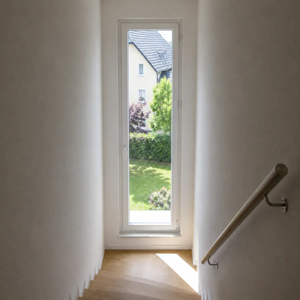 Schmales hohes Fenster an einer Podesttreppe im Treppenhaus von ecowindow