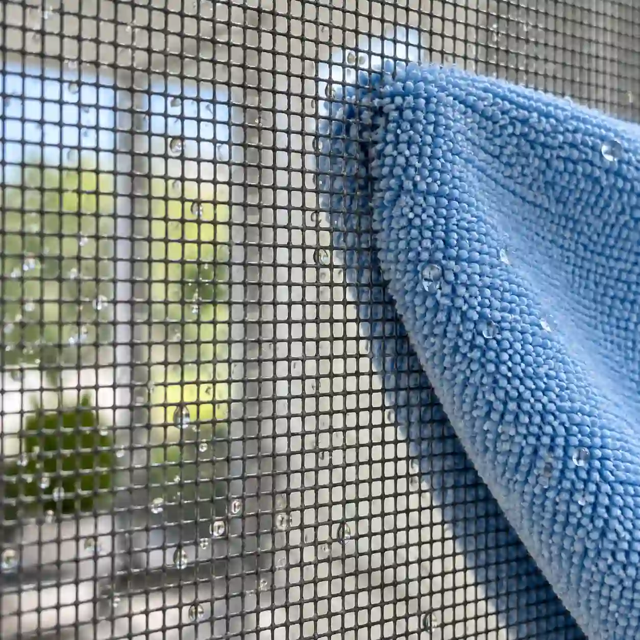 Insektenschutzgewebe reinigen Insektenschutzgewebe eines Vorbaurollladens wird mit einem Tuch abgewischt, bei ecowindow